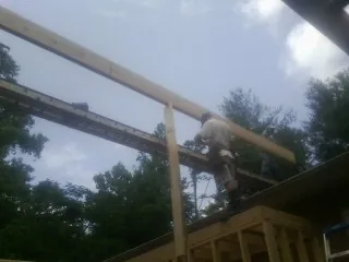 Carpenter setting a ridge beam over a new addition frame — Ice Dam Removal by Roofing Brothers in Port Republic