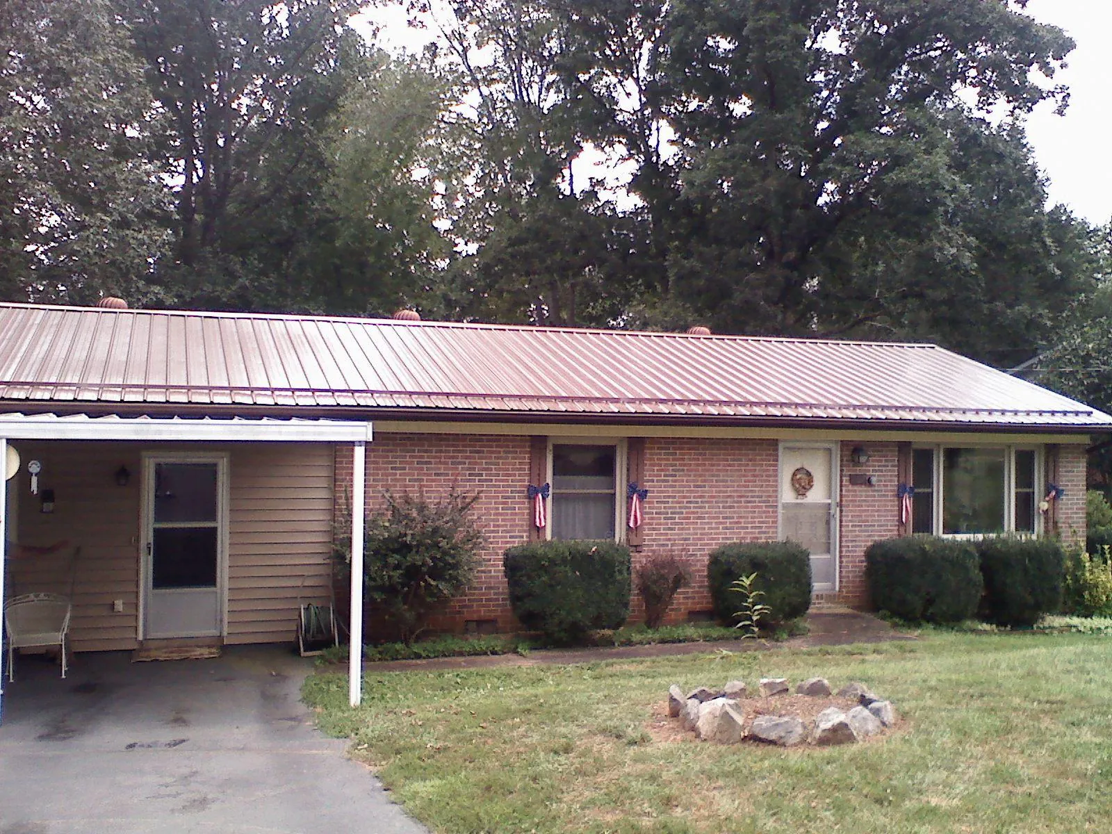 Bronze metal roof and carport on a brick ranch home — Roof Repair work by our crew in Port Republic